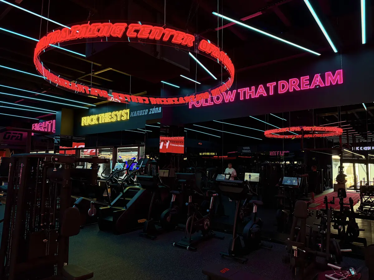Kruhový červený neon nad kardio zónou OFA Gym — realizace Neonworld
