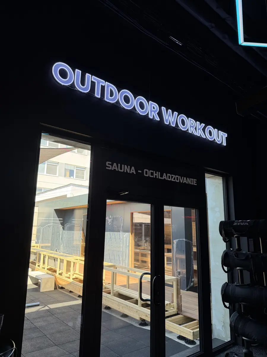 Neonový nápis Outdoor Workout nad vchodem v OFA Gym — realizace Neonworld